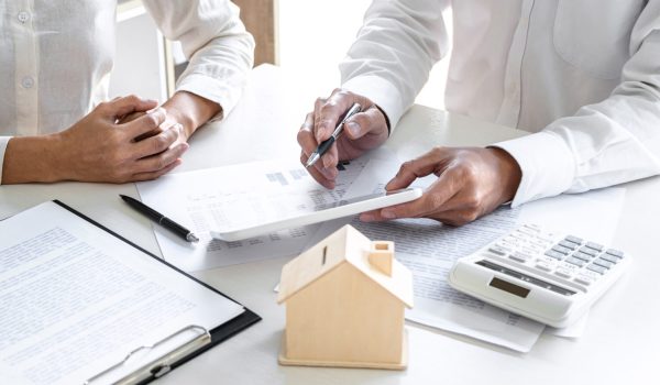 Real estate broker agent presenting and consult to customer to d Real estate broker agent presenting and consult to customer to decision making sign insurance form agreement, home model, concerning mortgage loan offer for and house insurance.